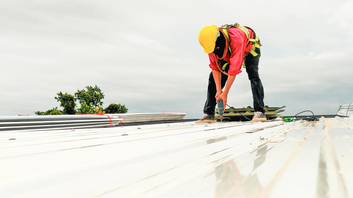 Construction worker install roof, Roofing tools, worke using Electric drill replacement install roof roof plates.